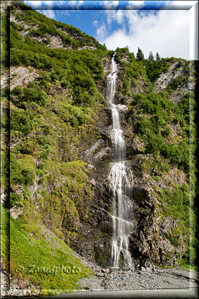 Alaska, es zeigt sich ein Wasserfall direkt am Highway