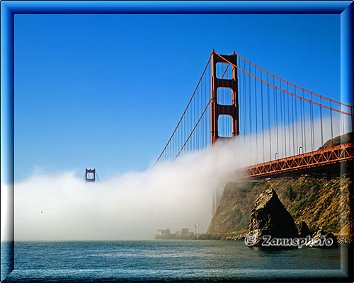 San Francisco, die Golden Gate Bridge steht im Fussbereich voll im Nebel, nur die Spitzen schauen heraus