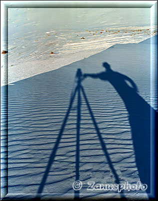 Schattenspiel, Stativ und Fotograf auf dem Sandboden
