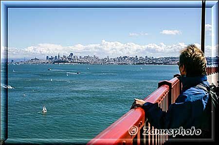 San Francisco, Besucherin schaut von der Bridge auf die in einiger Entfernung liegende City der Stadt
