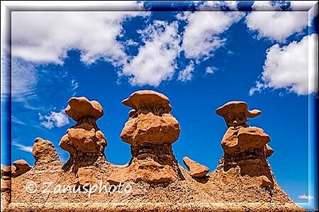Goblin Valley, auf einem Felsbogen befinden sich drei Gobline nebeneinander